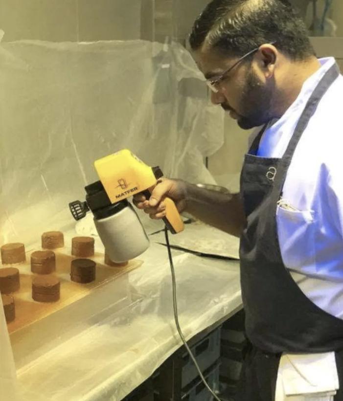 Chef using the Matfer M25 food sprayer to coat chocolate