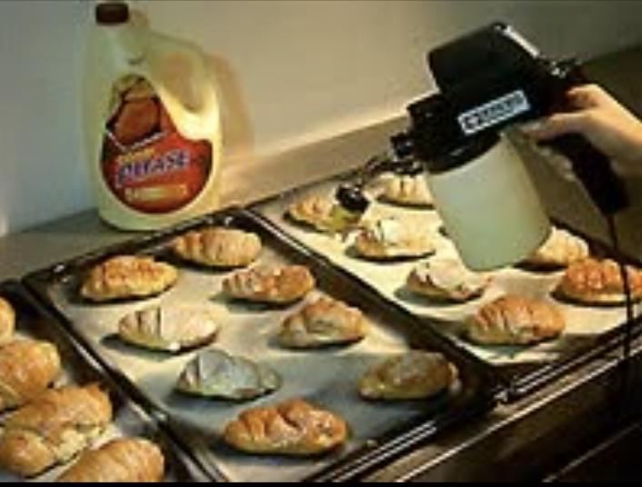 Food sprayer coating trays of pastries with release agent